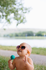 Image showing Baby in big sunglasses on a river