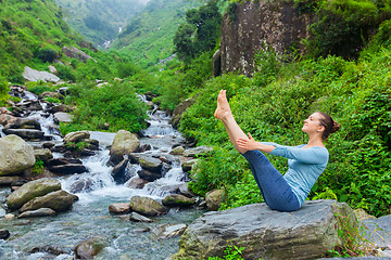 Image showing Woman doing Ashtanga Vinyasa Yoga asana Navasana outdoors