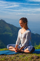 Image showing Sporty fit woman practices yoga asana Baddha Konasana outdoors
