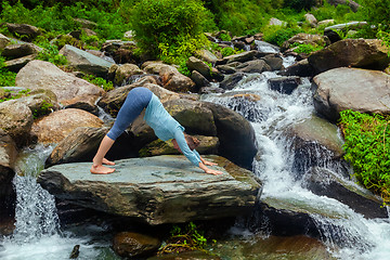 Image showing Young sporty fit woman doing yoga oudoors at tropical waterfall