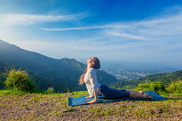 Image showing Woman practices yoga asana Urdhva Mukha Svanasana outdoors