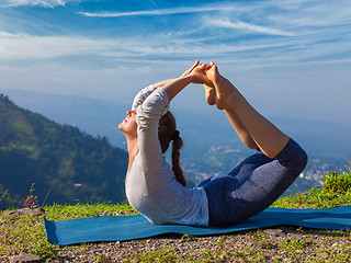 Image showing Woman doing Ashtanga Vinyasa Yoga asana Dhanurasana - bow pose