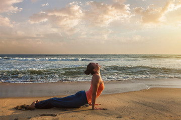 Image showing Woman practices yoga asana Urdhva Mukha Svanasana at the beach