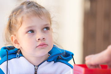 Image showing Sad girl sitting at the table looked up