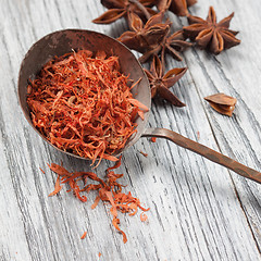 Image showing saffron in spoon with anise on wooden background