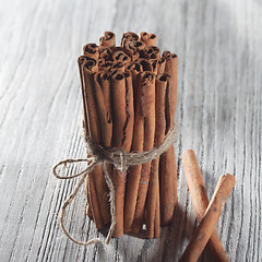 Image showing Cinnamon sticks isolated on white wooden table