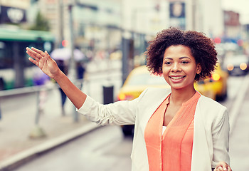 Image showing happy african woman catching taxi