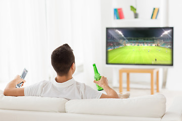 Image showing man watching soccer game on tv and drinking beer