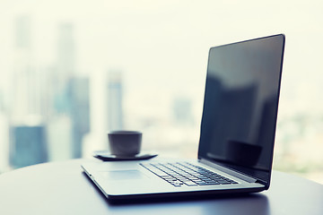 Image showing close up of laptop and coffee cup on office table