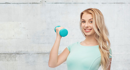 Image showing smiling beautiful young sporty woman with dumbbell