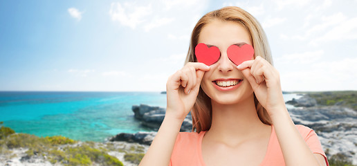 Image showing happy young woman with red heart shapes on eyes