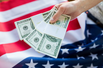 Image showing close up of hand with money over american flag