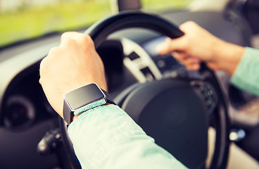 Image showing close up of man with wristwatch driving car