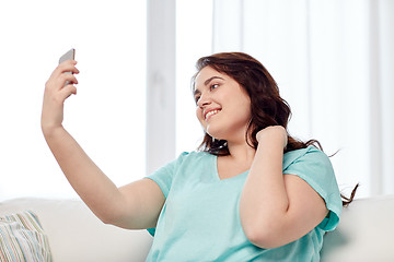 Image showing happy plus size woman with smartphone at home