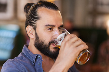 Image showing happy man drinking beer at bar or pub