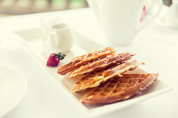 Image showing close up of waffles on plate at breakfast table 