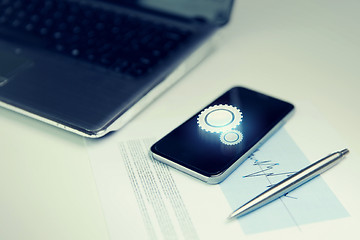 Image showing close up of smartphone, laptop and pen on table