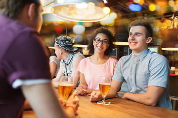 Image showing happy friends drinking beer and talking at bar