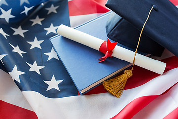 Image showing bachelor hat and diploma on american flag