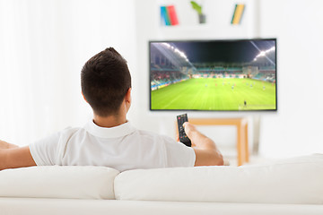 Image showing man watching football or soccer game on tv at home