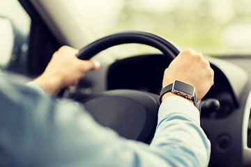 Image showing close up of man with wristwatch driving car