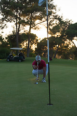 Image showing golf player aiming perfect  shot on beautiful sunset