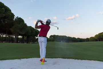 Image showing golfer hitting a sand bunker shot on sunset