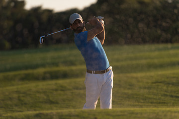 Image showing golfer hitting a sand bunker shot on sunset