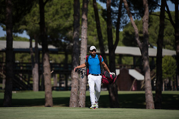 Image showing golf player walking and carrying bag