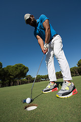 Image showing golf player hitting shot at sunny day, wide angle lens