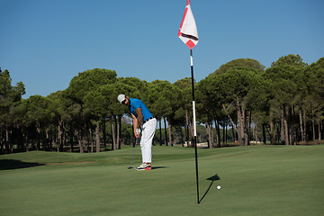 Image showing golf player hitting shot at sunny day