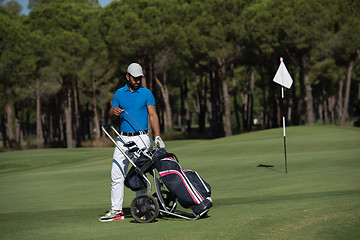 Image showing golf player walking with wheel bag