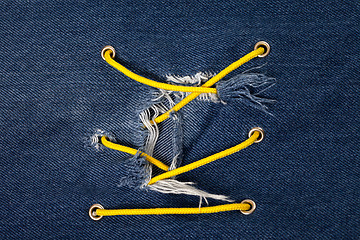 Image showing Blue jean with hole and crisscross lacing