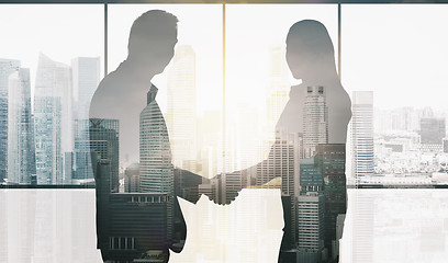 Image showing business partners silhouettes making handshake