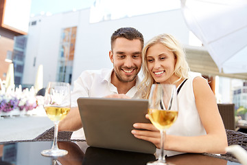 Image showing happy couple with tablet pc at restaurant terrace