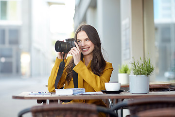 Image showing happy tourist woman with camera at city cafe