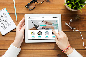 Image showing close up of woman with tablet pc on wooden table