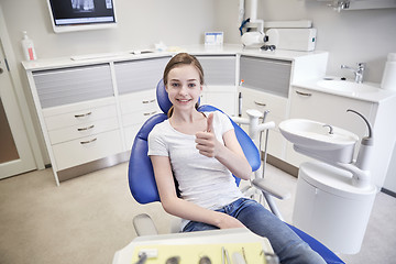 Image showing happy patient girl showing thumbs up at clinic