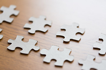 Image showing close up of puzzle pieces on wooden surface