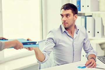 Image showing businessman taking folder from secretary in office