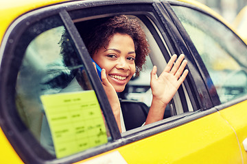 Image showing happy african woman calling on smartphone in taxi