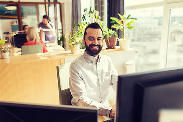 Image showing happy creative male office worker with computer