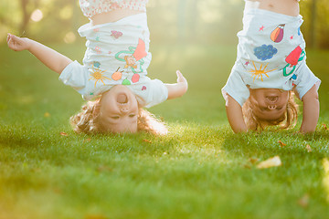 Image showing The two little baby girls hanging upside down