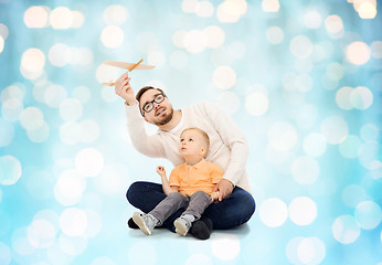 Image showing father and little son playing with toy airplane