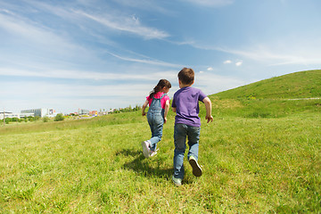 Image showing happy little boy and girl running outdoors