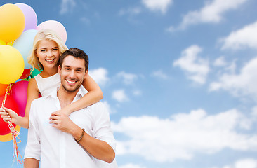 Image showing happy couple with balloons over blue sky