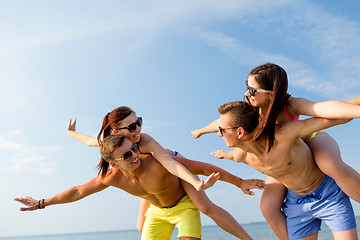 Image showing smiling friends having fun on summer beach