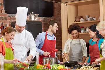 Image showing happy friends and chef cook cooking in kitchen