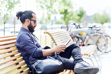 Image showing man with tablet pc sitting on city street bench