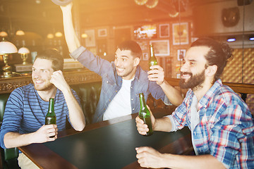 Image showing happy male friends drinking beer at bar or pub